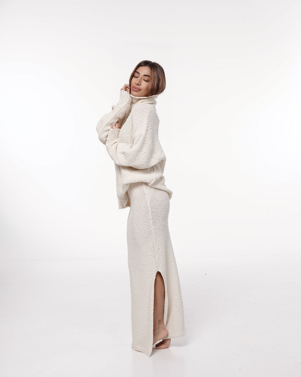 Side view of cream textured knit maxi skirt showing the long side slit