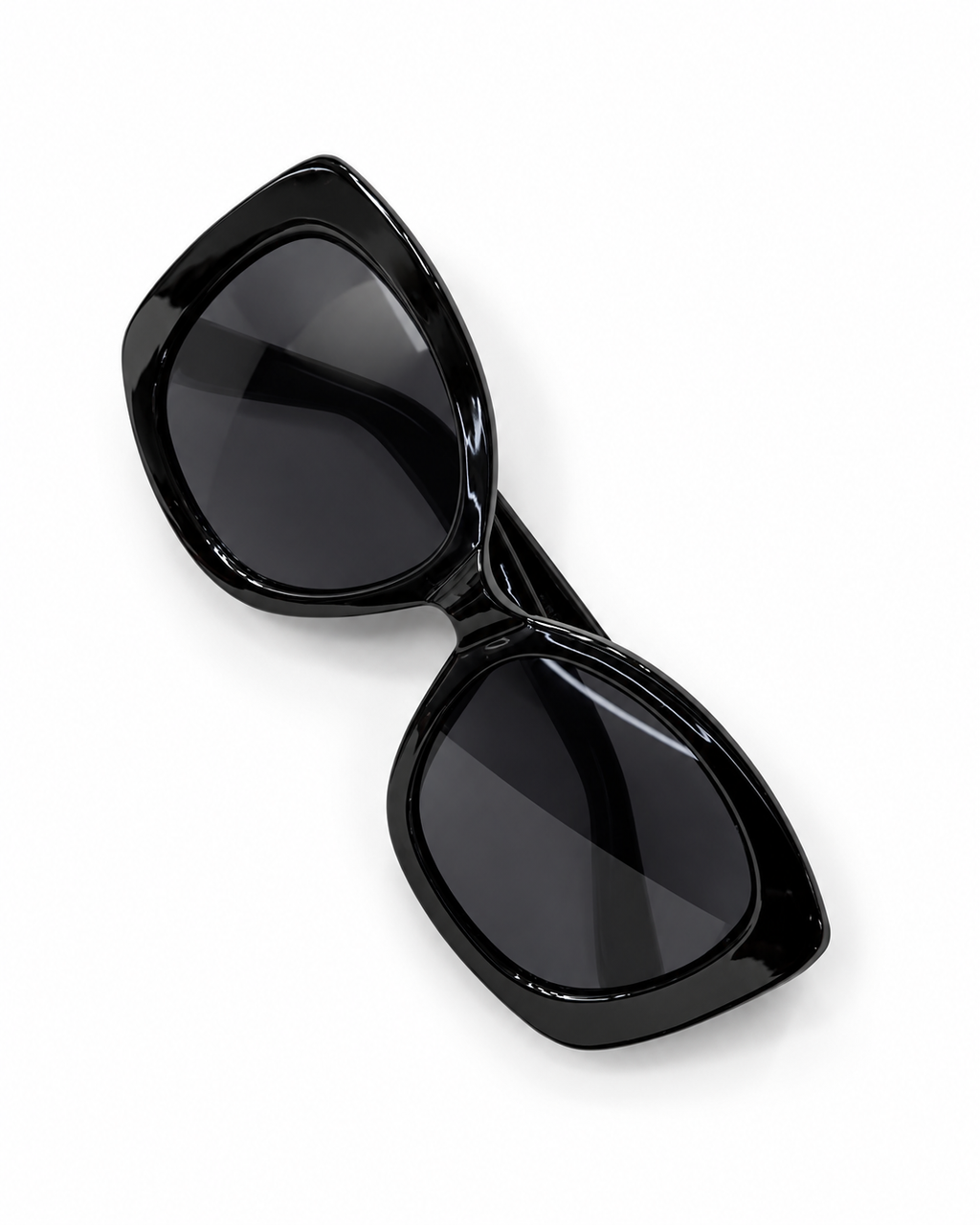 Glossy black oversized geometric sunglasses with dark UV400 lenses, photographed from above.